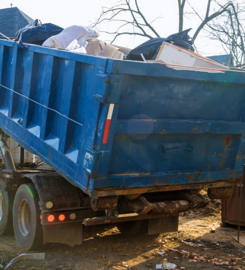 Removal of debris construction waste building demolition with rock and concrete rubble on portable bio toilet cabins at the construction site